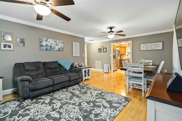 living room with ceiling fan, wood-type flooring, and crown molding