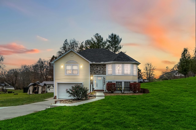 bi-level home featuring a yard and a garage