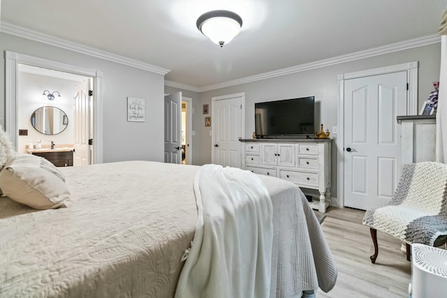 bedroom featuring light wood-type flooring, connected bathroom, and crown molding