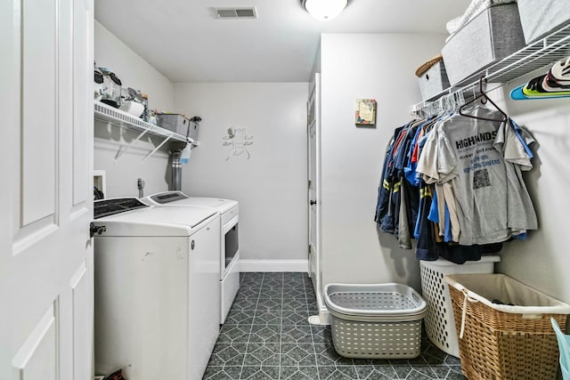 washroom with dark tile patterned floors and independent washer and dryer