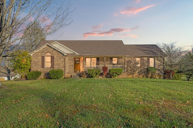 single story home featuring a yard and covered porch