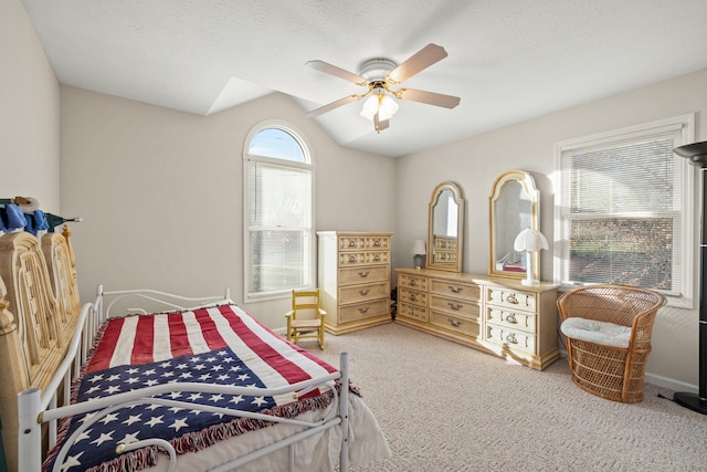 bedroom with carpet flooring, ceiling fan, a textured ceiling, and vaulted ceiling