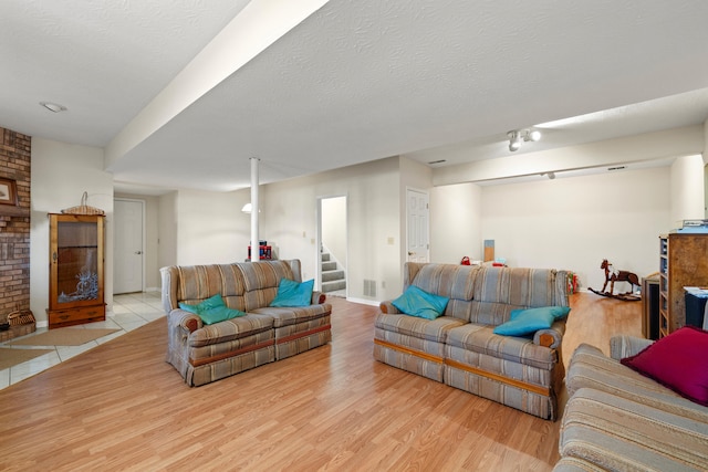 living room featuring light hardwood / wood-style floors and a textured ceiling