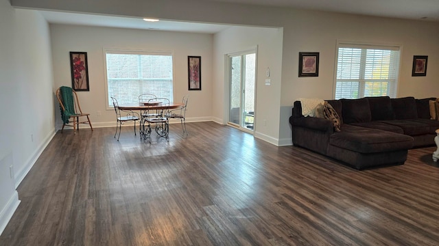 living room with dark hardwood / wood-style floors and a healthy amount of sunlight