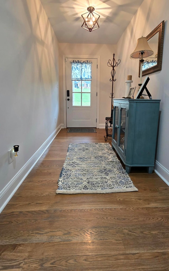 entrance foyer featuring dark wood-type flooring and a notable chandelier