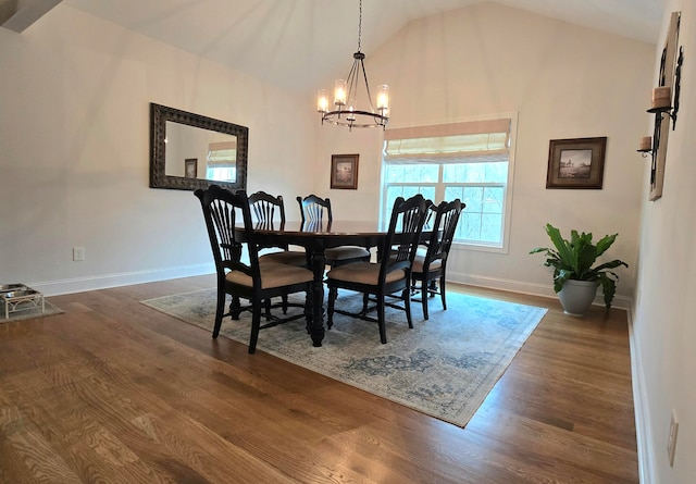 dining room with dark hardwood / wood-style floors, high vaulted ceiling, and a chandelier