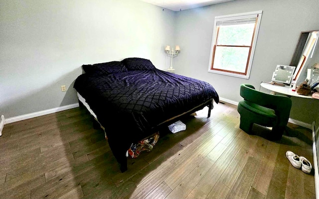 bedroom with dark hardwood / wood-style flooring