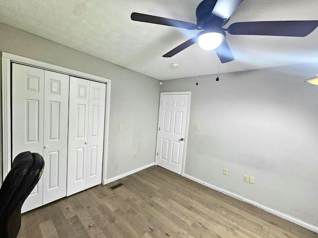 unfurnished office with ceiling fan and hardwood / wood-style floors