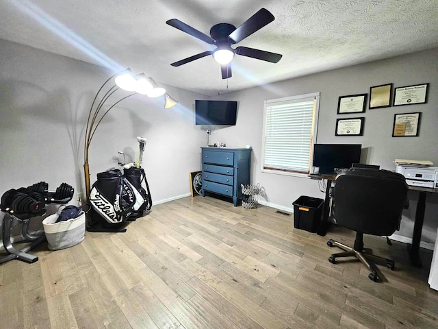 office area with ceiling fan, light hardwood / wood-style floors, and a textured ceiling