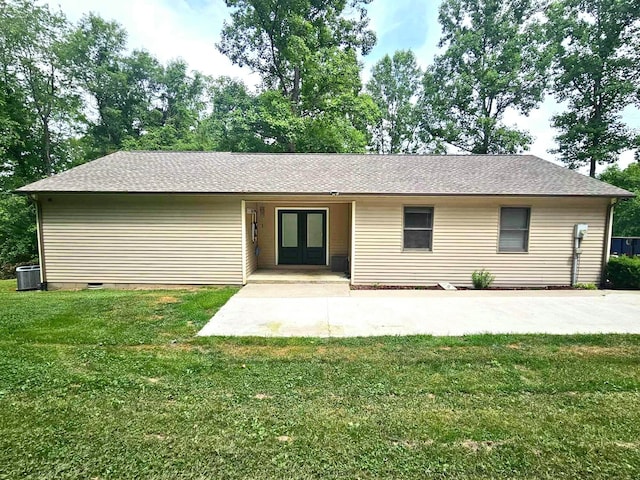 back of property featuring french doors, central AC unit, and a lawn