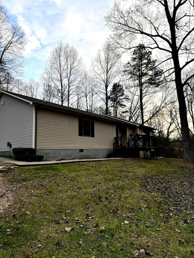 view of property exterior featuring a wooden deck and a yard