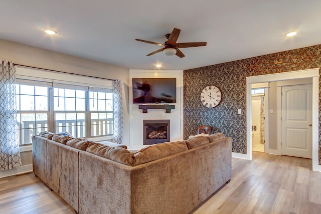 living room featuring light hardwood / wood-style flooring and ceiling fan