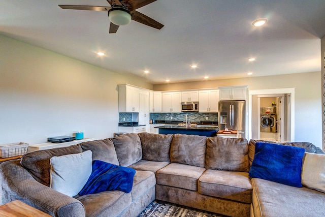 living room with ceiling fan, sink, and washer / dryer