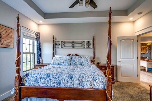 bedroom featuring carpet flooring, ceiling fan, and a tray ceiling