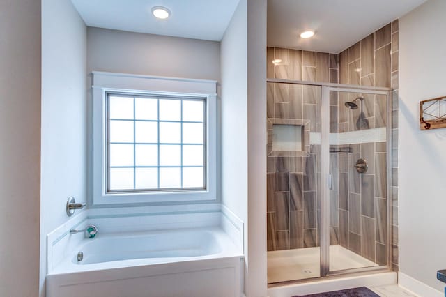 bathroom featuring independent shower and bath