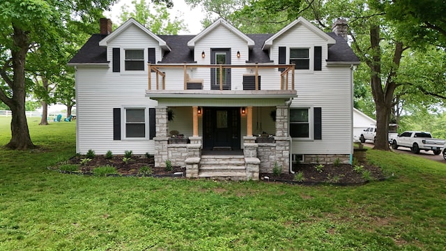 view of front facade featuring a porch, a balcony, and a front yard