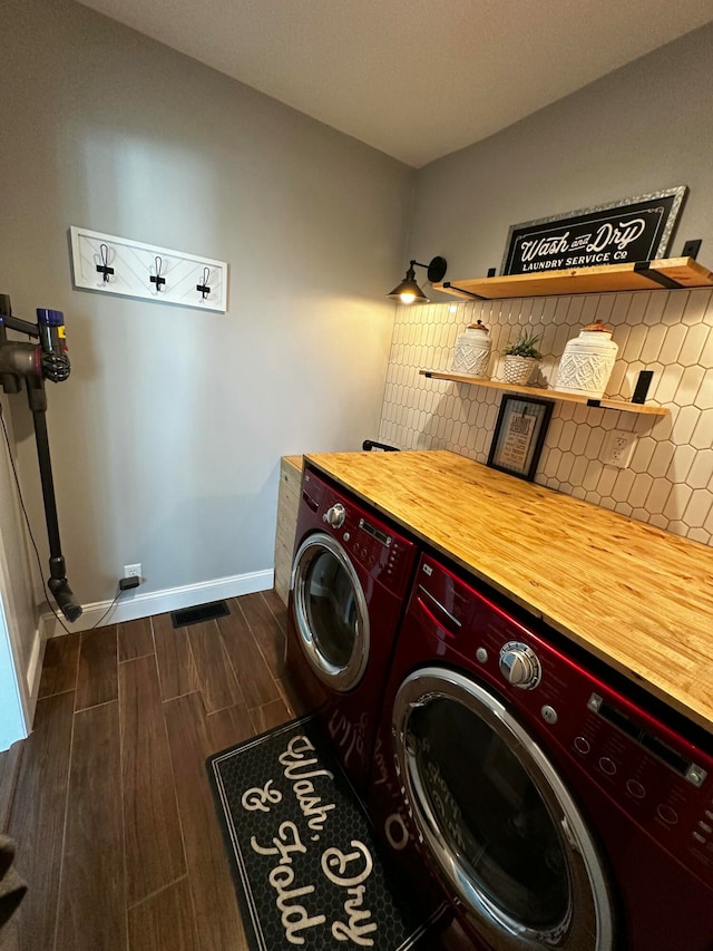 laundry area featuring dark hardwood / wood-style flooring and washing machine and clothes dryer