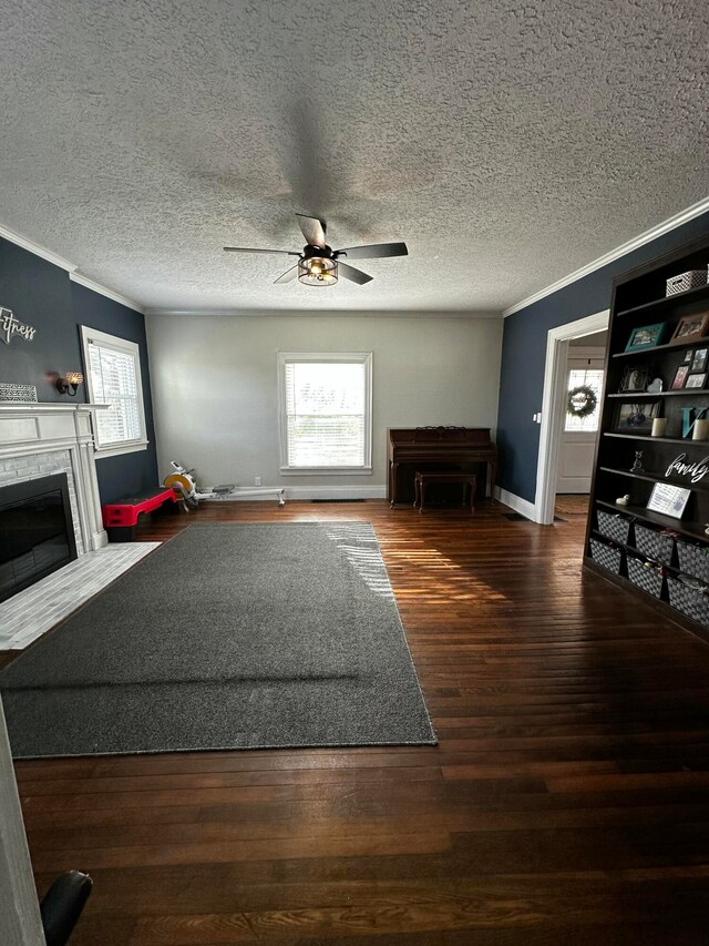 unfurnished living room featuring a textured ceiling, crown molding, ceiling fan, and dark wood-type flooring