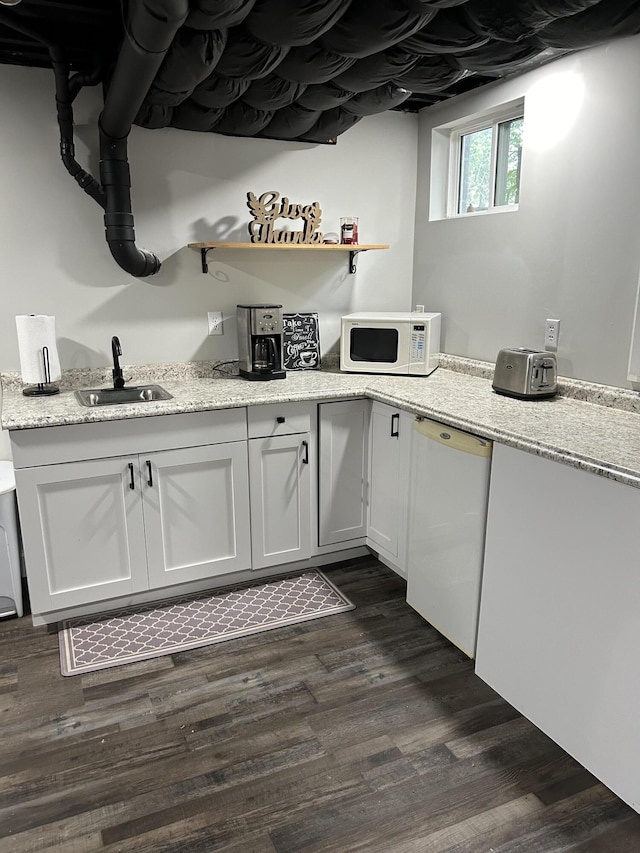 bar with light stone countertops, dishwasher, sink, dark hardwood / wood-style flooring, and white cabinets