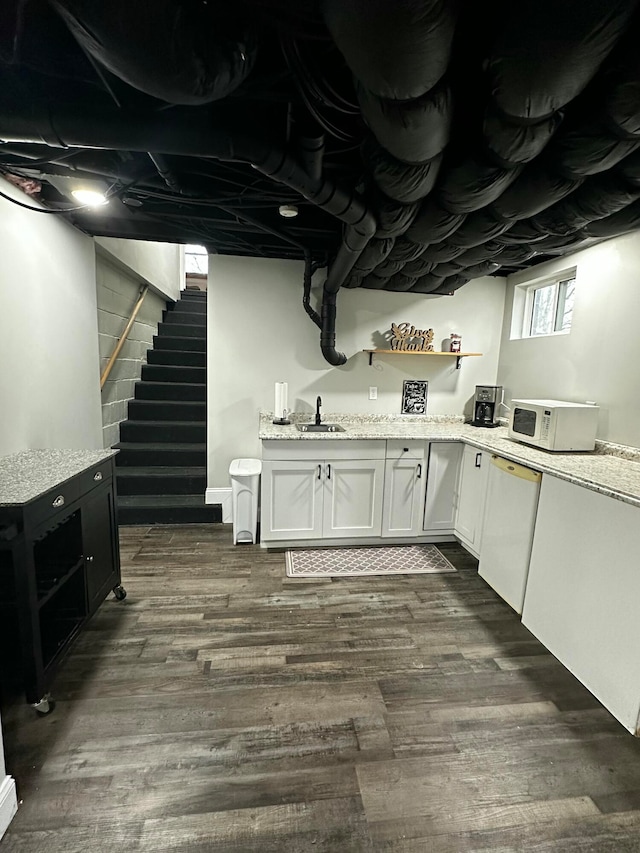 basement featuring dark hardwood / wood-style floors and sink