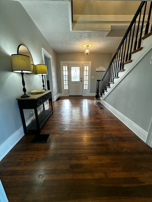 entrance foyer with dark hardwood / wood-style flooring and a textured ceiling