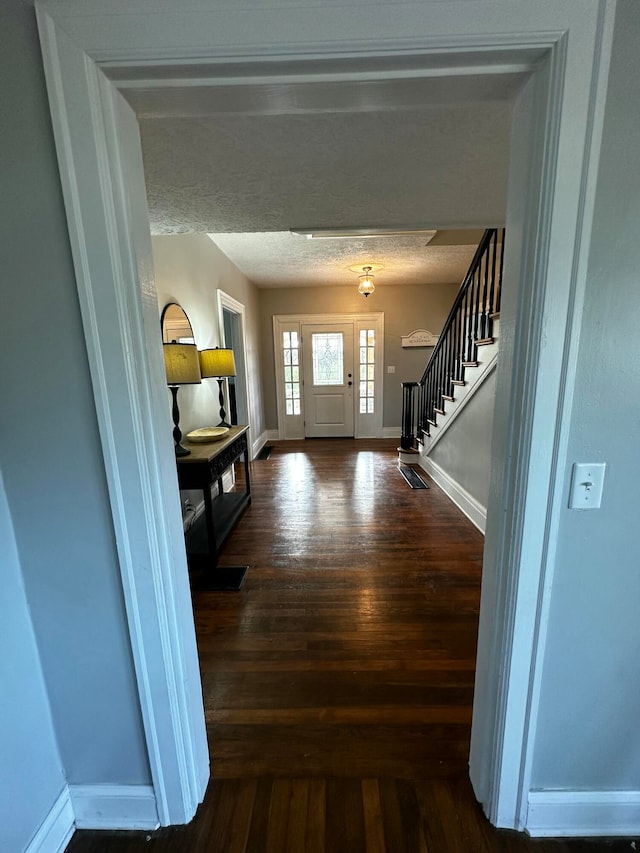 entryway featuring a textured ceiling and dark wood-type flooring