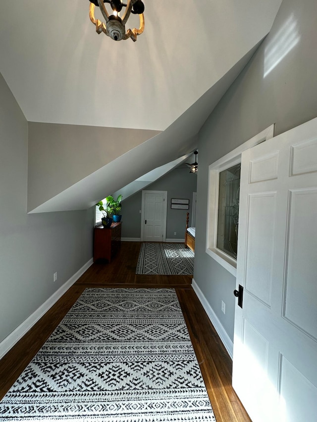 bonus room with a notable chandelier, dark hardwood / wood-style flooring, and lofted ceiling