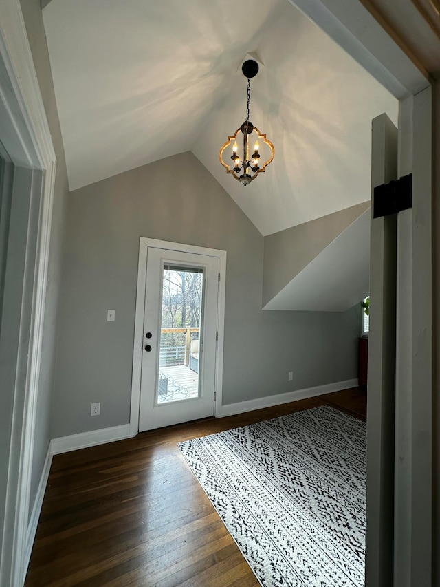 doorway featuring dark hardwood / wood-style flooring, lofted ceiling, and a chandelier