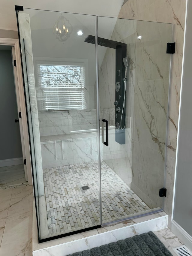 bathroom featuring an enclosed shower and an inviting chandelier