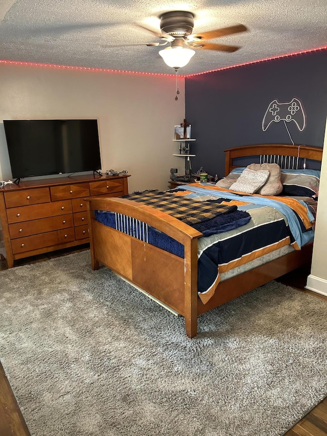 bedroom featuring hardwood / wood-style flooring, ceiling fan, and a textured ceiling