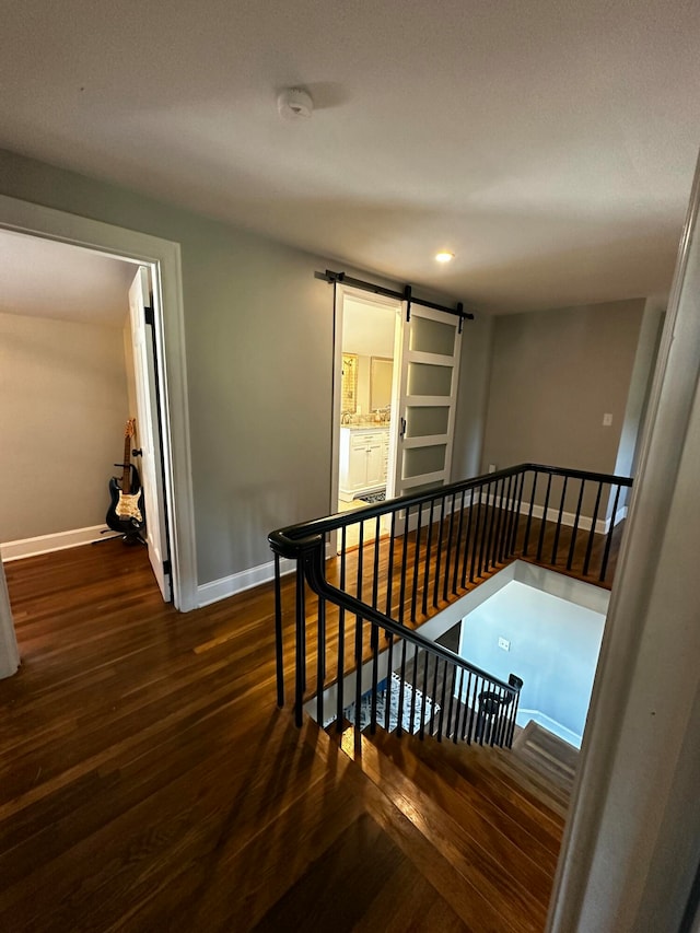 stairs featuring a barn door and hardwood / wood-style floors