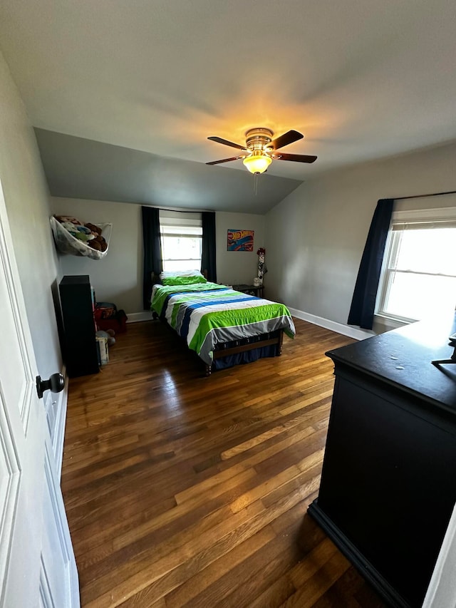 bedroom with multiple windows, ceiling fan, dark hardwood / wood-style flooring, and vaulted ceiling