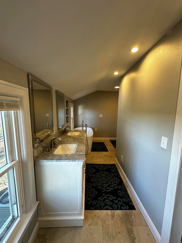 bathroom featuring tile patterned flooring, vanity, and vaulted ceiling