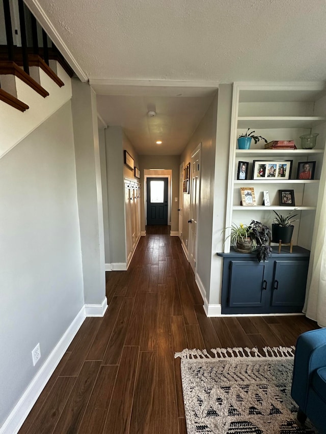 corridor with dark hardwood / wood-style floors and a textured ceiling