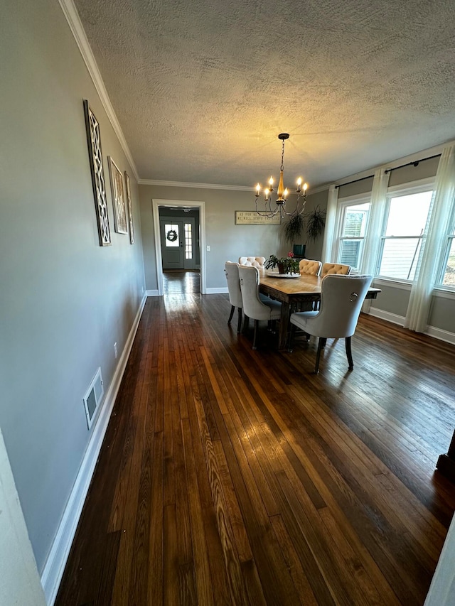 dining area with ornamental molding, dark hardwood / wood-style flooring, a textured ceiling, and a notable chandelier