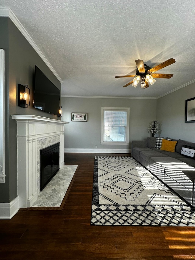 living room featuring ceiling fan, dark hardwood / wood-style flooring, a premium fireplace, and ornamental molding