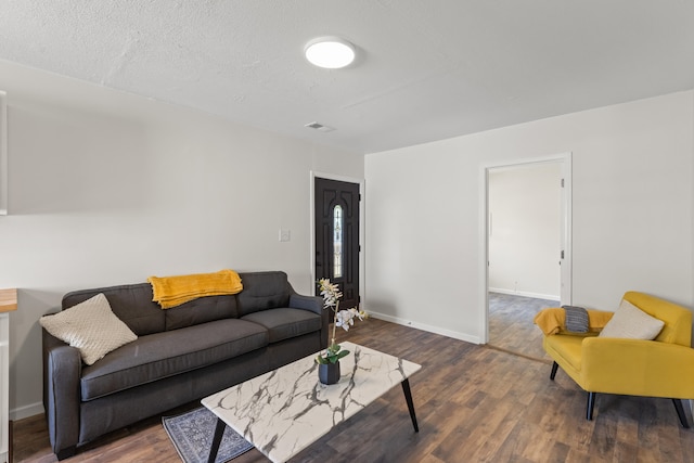 living room with a textured ceiling and dark wood-type flooring