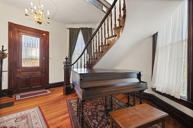 foyer entrance featuring hardwood / wood-style floors and an inviting chandelier