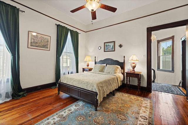 bedroom with multiple windows, ceiling fan, and dark hardwood / wood-style floors