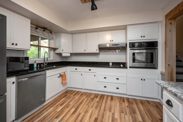 kitchen with white cabinets, light hardwood / wood-style floors, sink, and appliances with stainless steel finishes