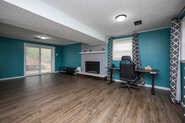 office space featuring wood-type flooring, a textured ceiling, and a brick fireplace