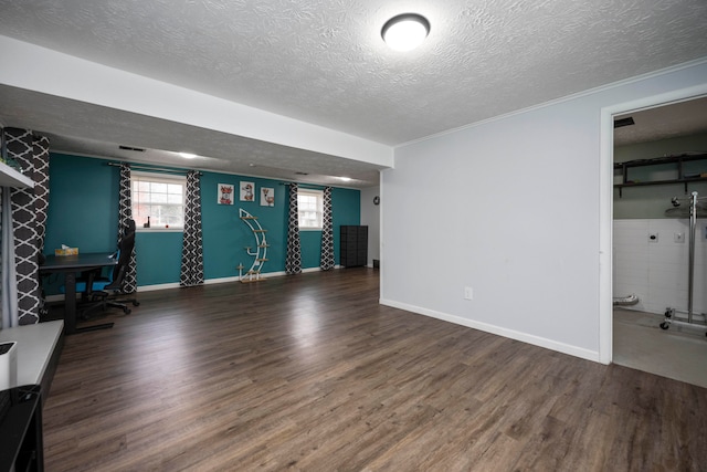 basement with dark hardwood / wood-style flooring, ornamental molding, and a textured ceiling