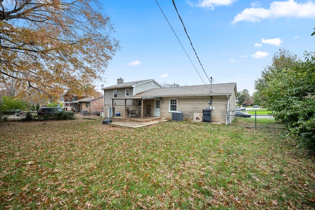 rear view of property featuring a yard, central AC unit, and a patio area