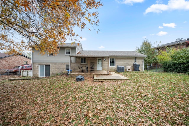 back of house with central AC, a deck, and a lawn