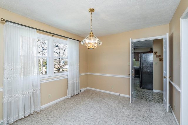 unfurnished room featuring carpet flooring, a notable chandelier, and a textured ceiling