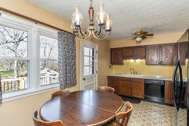 dining space featuring a textured ceiling, ceiling fan with notable chandelier, plenty of natural light, and sink