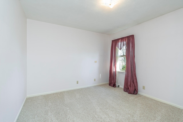 carpeted spare room with a textured ceiling