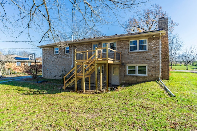 rear view of house featuring a deck and a lawn