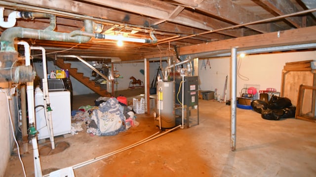 basement with heating unit, water heater, and washer / dryer