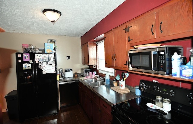 kitchen with black appliances, dark hardwood / wood-style floors, sink, and a textured ceiling